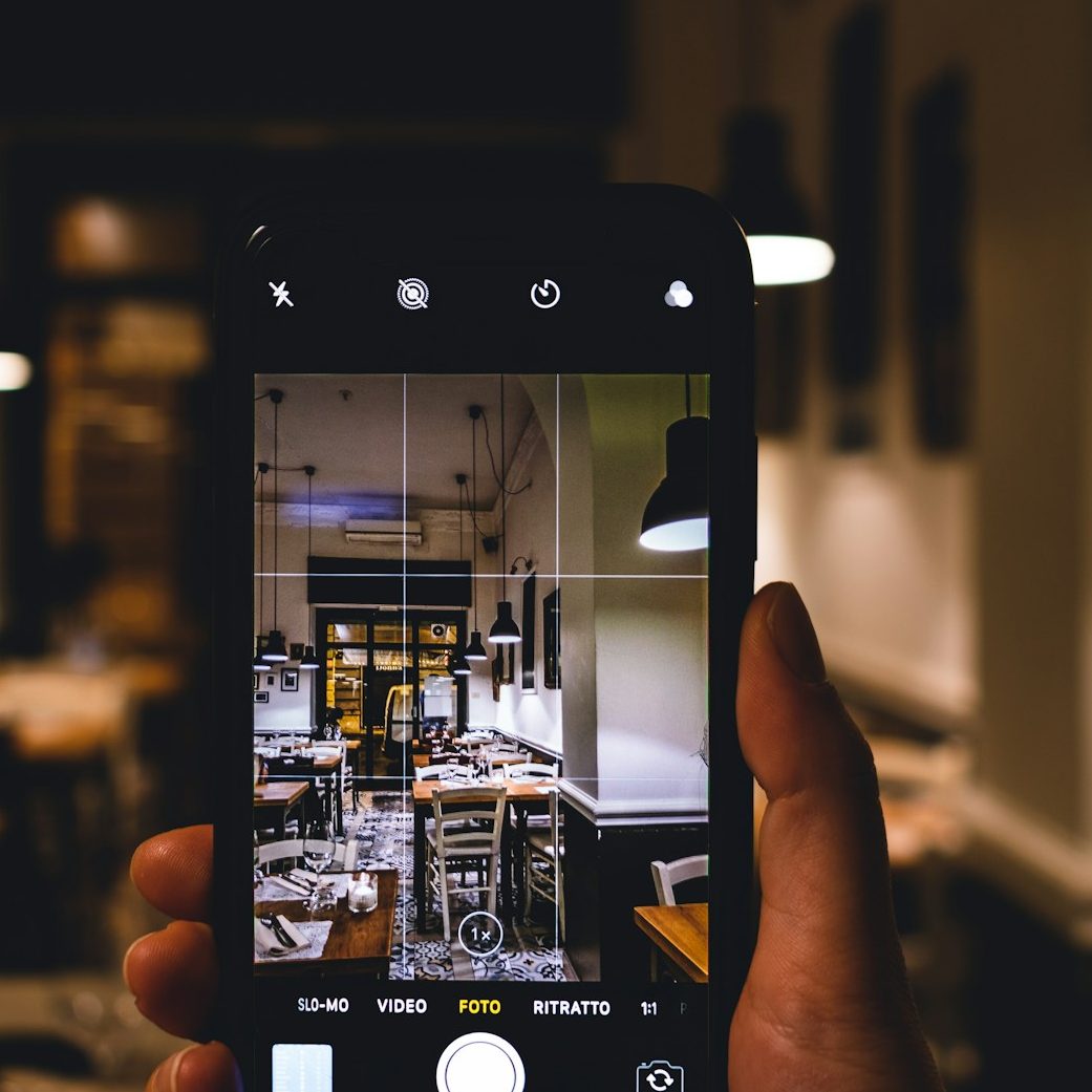 this is an image showing a cellphone taking a picture of a restaurant
